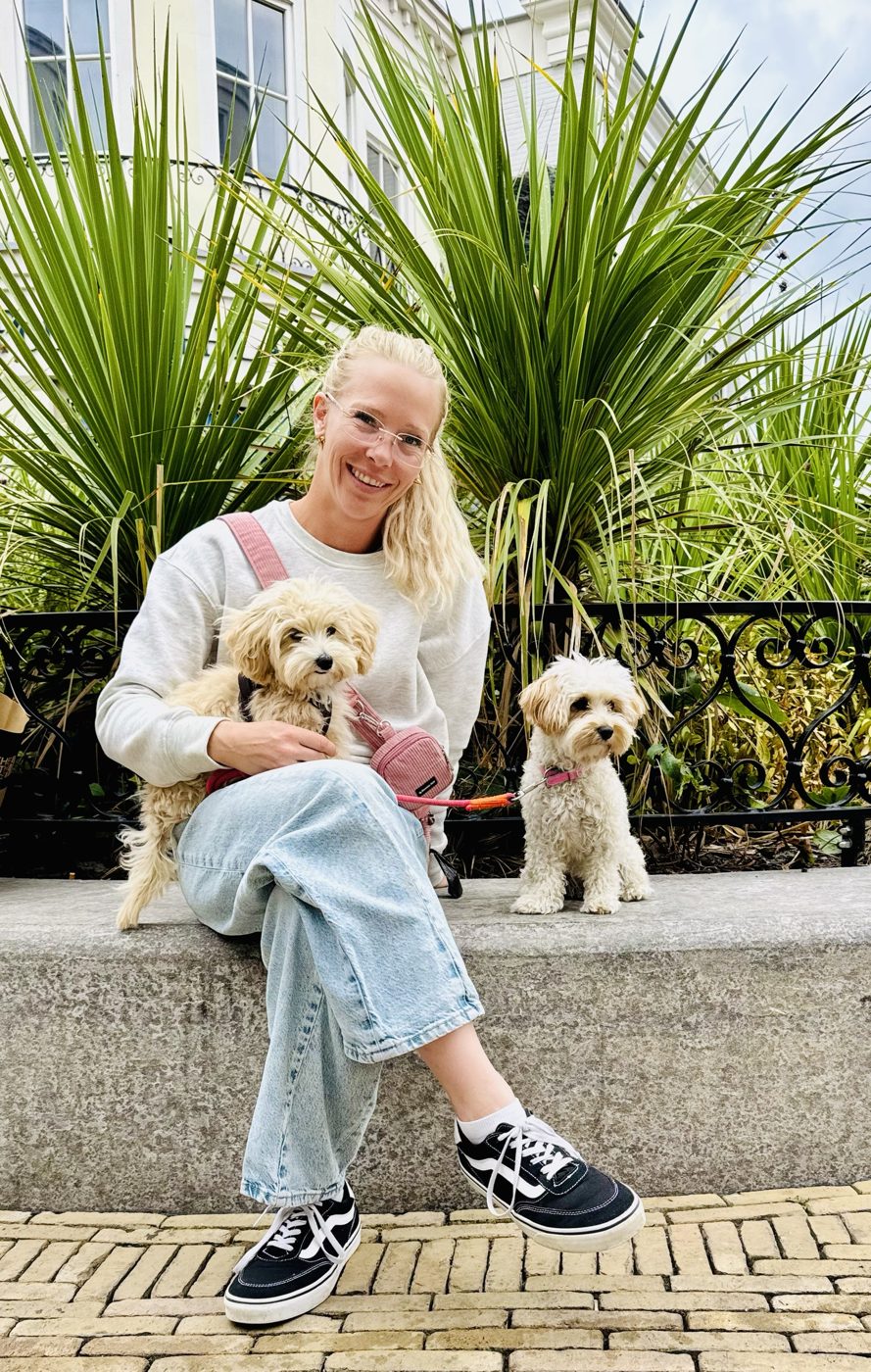 Vanessa sitzt auf einer Mauer mit Majo auf dem Schoß und Heidi daneben